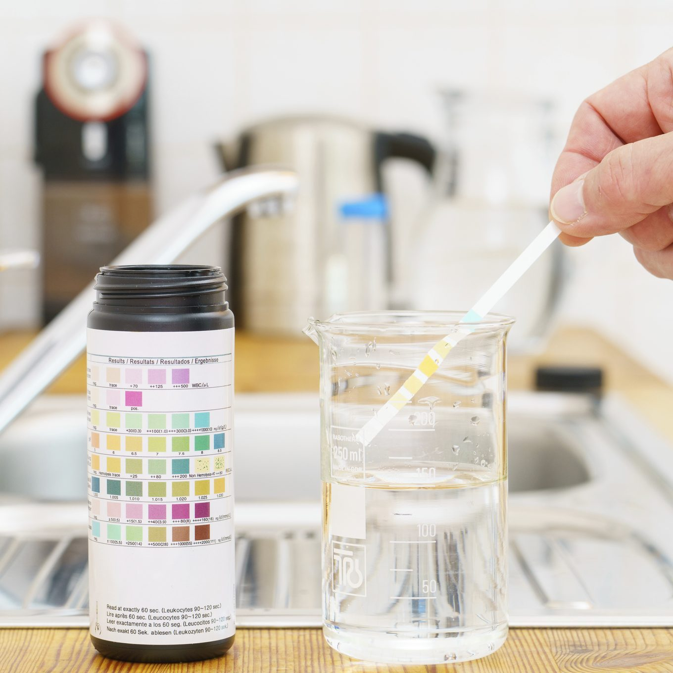 Multi water test kit in a kitchen. single kit bundles several small tests into one box, so you can check for many things at once, typically chlorine, pH, nitrates, nitrites, iron, copper, lead, pesticides, hardness and bacteria